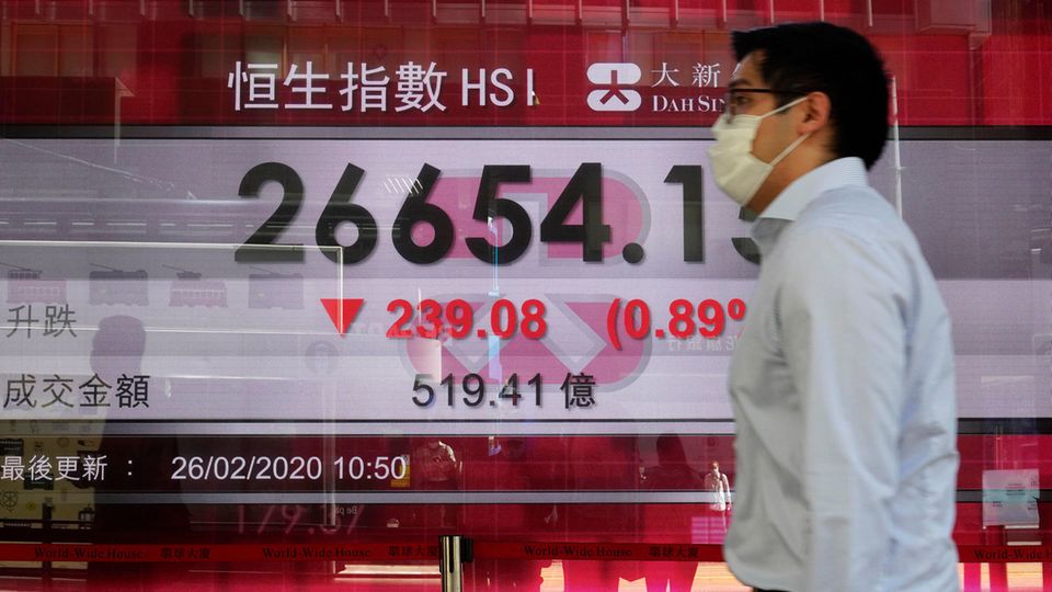 Ein Mann geht an einer Anzeigentafel der Hongkonger Börse vorbei.