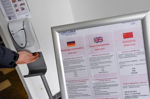 Am Eingang zur privaten Hochschule Diploma in Hessen kann man neben einem Coronavirus-Warnschild seine Hände desinfizieren