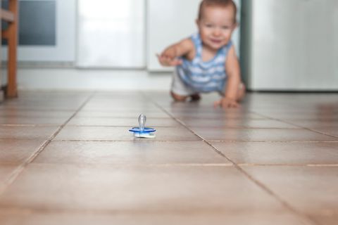 Ein Baby krabbelt zu einem Schnuller