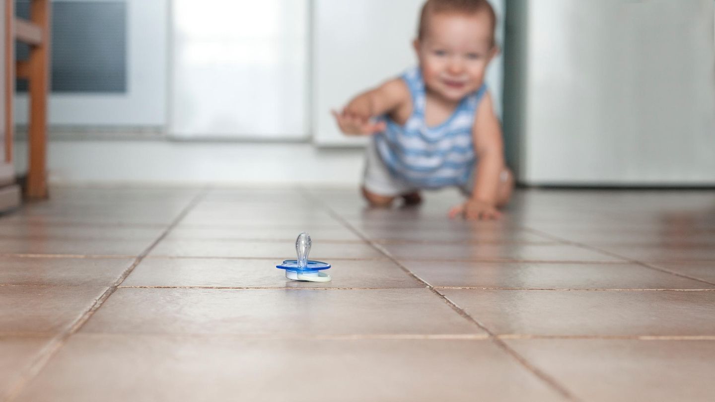 Ein Baby krabbelt zu einem Schnuller