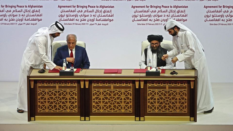 US-Vertreter Zalmay Khalilzad und Taliban-Mitgründer Mullah Abdul Ghani Baradar unterzeichnen das US-Taliban-Abkommen US-Vertreter Zalmay Khalilzad und Taliban-Mitgründer Mullah Abdul Ghani Baradar unterzeichnen das US-Taliban-Abkommen