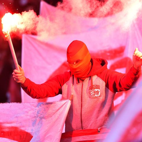 Ein Bayern-Fans mit brennenden Bengalos