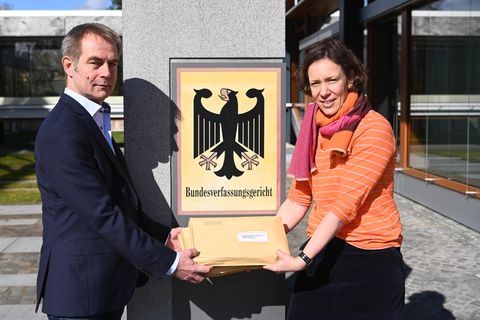 Ein Mann und eine Frau stehen vor dem Eingang des Bundesverfassungsgerichts