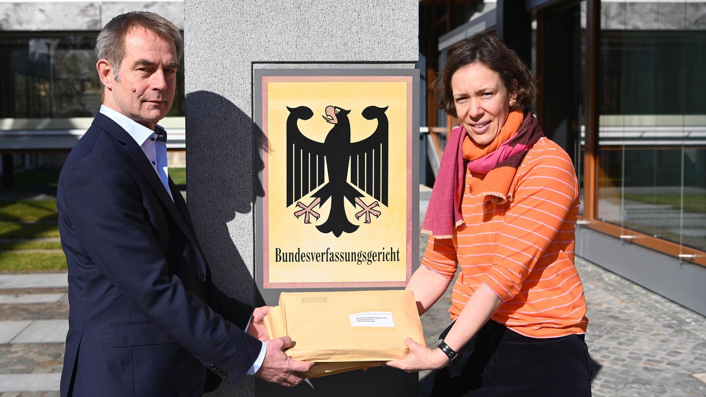 Ein Mann und eine Frau stehen vor dem Eingang des Bundesverfassungsgerichts