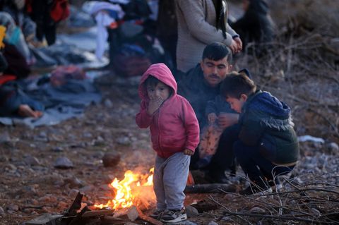 Migranten, die aus der Türkei eingetroffen sind, wärmen sich auf der Insel Lesbos an einem Feuer