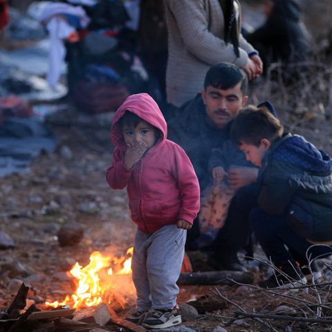 Migranten, die aus der Türkei eingetroffen sind, wärmen sich auf der Insel Lesbos an einem Feuer