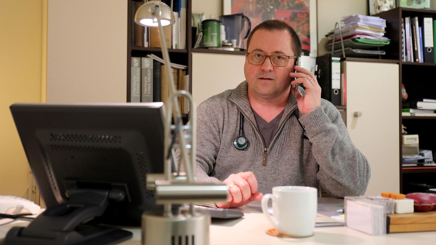 Hausarzt Coronavirus: Ein Arzt sitzt am Schreibtisch und telefoniert