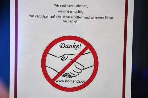 Ein Schild warnt angesichts des Coronavirus vor dem Händeschütteln