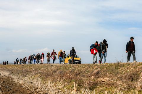 Migranten gehen in der Nähe des Grenzüberganges in Edirne eine Straße entlang
