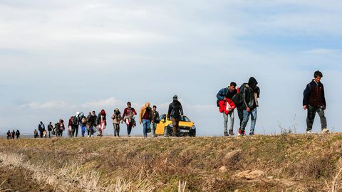 Migranten gehen in der Nähe des Grenzüberganges in Edirne eine Straße entlang