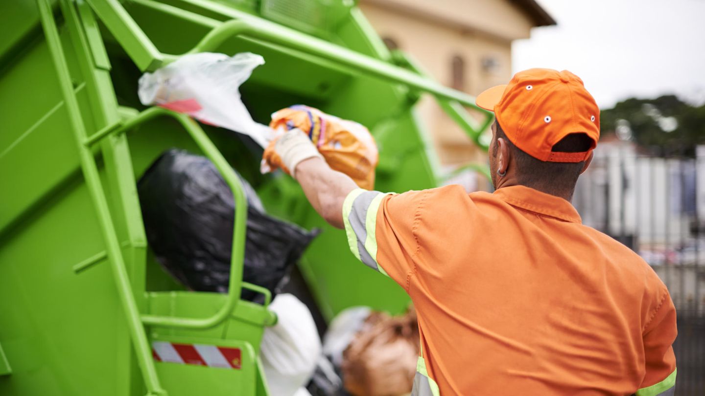 Müllmann wirft Müllsäcke ins Fahrzeug