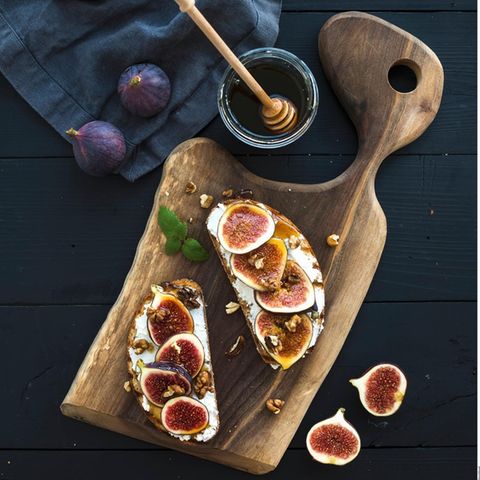 VOE STERN GESUND LEBEN 6/2019  VOE STERN GESUND LEBEN 6/2019  Zwei Brote mit Ricotta, frischen Feigen, WalnŸssen und Honig auf rustikalen Holzbrett Brote mit Feige,Walnuss und Honig
