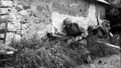 Deutsche Fallschirmspringer mit dem Panzerschreck in der Normandie. Der Schütze sucht die Deckung durch das Gebäude.