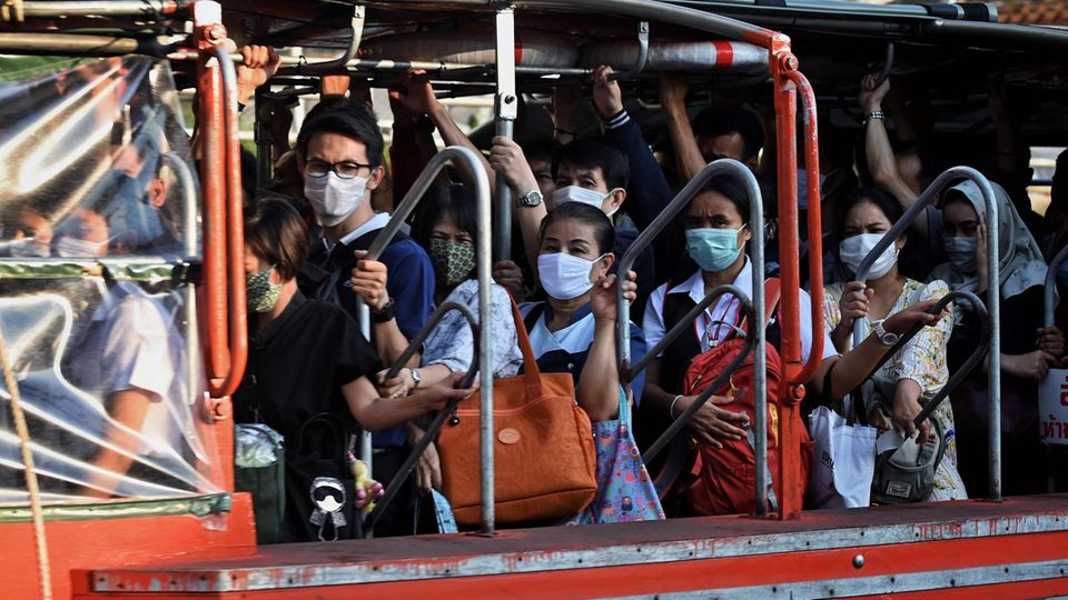 Menschen in Thailand tragen Mundschutz um sich vor dem Coronavirus zu schützen