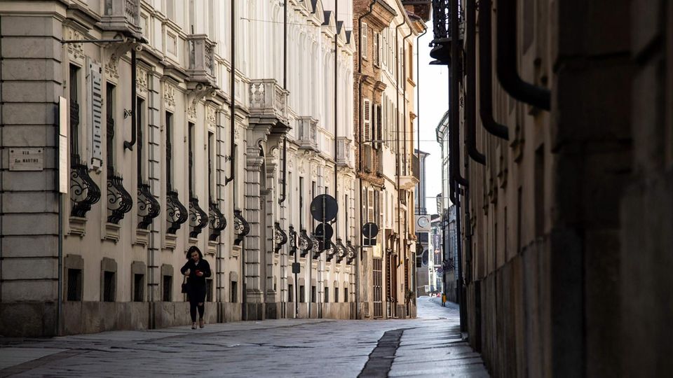 Eine Frau läfut durch die leeren Straßen im norditalienischen Asti