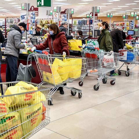 Kunden stehen im Kassenbereich eines Supermarktes