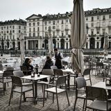 Zwei mutige Gäste auf einer verlassenen Caféterrasse auf der Piazza Vittorio in Turin. Bars und Restaurants können vorerst von 6 bis 18 Uhr geöffnet bleiben, sofern ein Sicherheitsabstand von mindestens einem Meter zwischen den Gästen eingehalten wird.