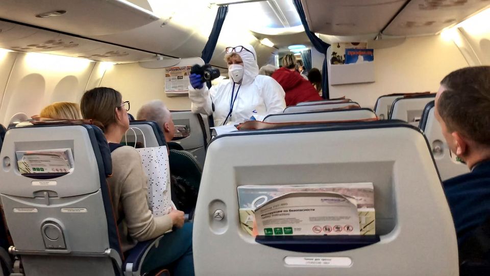 Moskau: Ein Arzt kontrolliert die Temperatur der Passagiere in einem Flugzeug, welches aus Italien eintrifft. Moskau: Ein Arzt kontrolliert die Temperatur der Passagiere in einem Flugzeug, welches aus Italien eintrifft.
