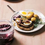 Baltischer Hering      Zutaten:  300 g Heringfillets mit Haut, 30 g Butter, 1 Zwiebel, gewürfelt, 2 EL Hanfsamen 700 g Babykartoffeln      Marinade:  4 Gewürznelken, 2 kleine Zimtstangen, 4 Lorbeerblätter, 1 EL schwarze Pfefferkörner, 80 ml Weißweinessig, 70 g Zucker, 200 g Heidelbeeren (gefroren oder frisch)      Zum Servieren:  8 Scheiben Roggenbrot, 2 hart gekochte Eier, halbiert, 30 g frischer Meerettich, geschält, Dillstängel          Zubereitung:  Heringsfilets abspülen und in 5 cm große Stücke schneiden. In ein großes sauberes Glas (oder zwei kleinere) füllen, dabei etwas Platz für die Marinade lassen.  Für die Marinade alle Zutaten außer den Heidelbeeren mit 150 ml Wasser in einem Topf zum Kochen bringen, dann vom Herd nehmen. Frische Heidelbeeren vorsichtig waschen. Dann die Heidelbeeren zum Wasser hinzufügen und die Marinade vollständig auskühlen lassen. Wenn sie kalt geworden ist, über den Hering gießen, sodass er davon ganz bedeckt ist. Verschlossen im Kühlschrank 2–3 Tage marinieren lassen.  In einer Bratpfanne die Butter schmelzen und darin die Zwiebel bei mittlerer Hitze anschwitzen. Die Hanfsamen hinzufügen und weitere 2–3 Minuten garen, bis die Samen leicht gebräunt sind. Dann die Pfanne vom Herd nehmen und die Mischung beiseitestellen. In einem Topf Wasser zum Kochen bringen. Die Kartoffeln hinzufügen und in etwa 10 Minuten weich garen. In ein Sieb abgießen.  Zum Servieren die marinierten Heringsstücke gleichmäßig auf die Teller aufteilen und die Hanfmischung daraufgeben. Dazu Kartoffeln, Brotscheiben und hart gekochte Eier servieren. Den frischen Meerrettich darüber reiben und das Gericht mit Dillstängeln garnieren.