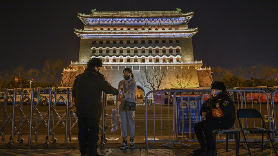 Bei einer Frau wird in Peking die Temperatur gemessen