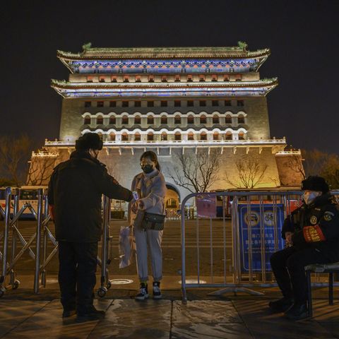 Bei einer Frau wird in Peking die Temperatur gemessen