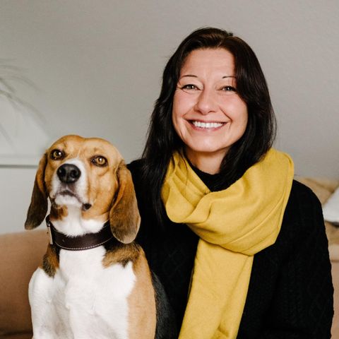 Beagle Toffee und seine dunkelhaarige Besitzerin. Sie trägt einen gelben Schal