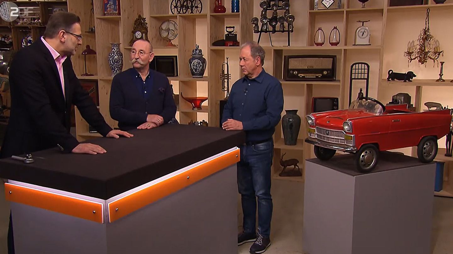 Drei Männer und das Spielzeugauto: "Bares für Rares"-Experte Detlev Kümmel und Moderator Horst Lichter sprechen über das Objekt von Hubert Büttgenbach (v.l.)