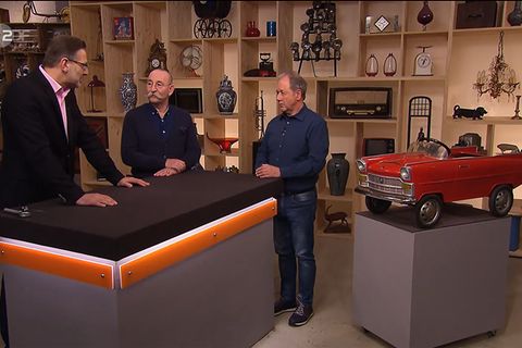 Drei Männer und das Spielzeugauto: "Bares für Rares"-Experte Detlev Kümmel und Moderator Horst Lichter sprechen über das Objekt von Hubert Büttgenbach (v.l.)