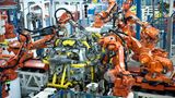 Zahlreiche Roboter arbeiten am Montageband an einem Auto