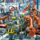 Zahlreiche Roboter arbeiten am Montageband an einem Auto