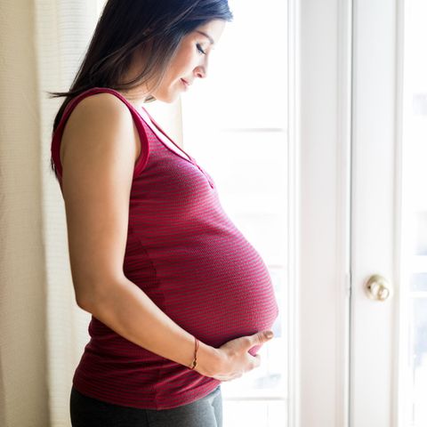 Schwangerschaft und Coronavirus: Eine schwangere Frau fasst sich an den Bauch