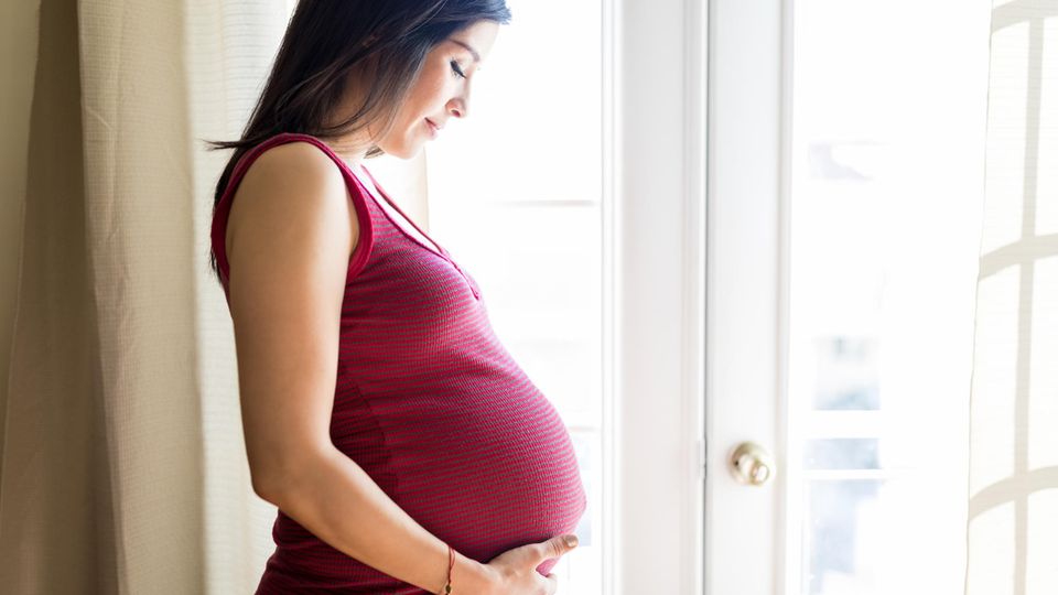Schwangerschaft und Coronavirus: Eine schwangere Frau fasst sich an den Bauch