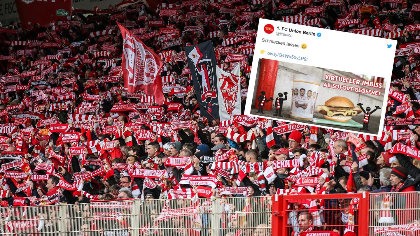 Fans des 1. FC Union Berlin recken rot-weiße Schals ihres Klub in die Höhe