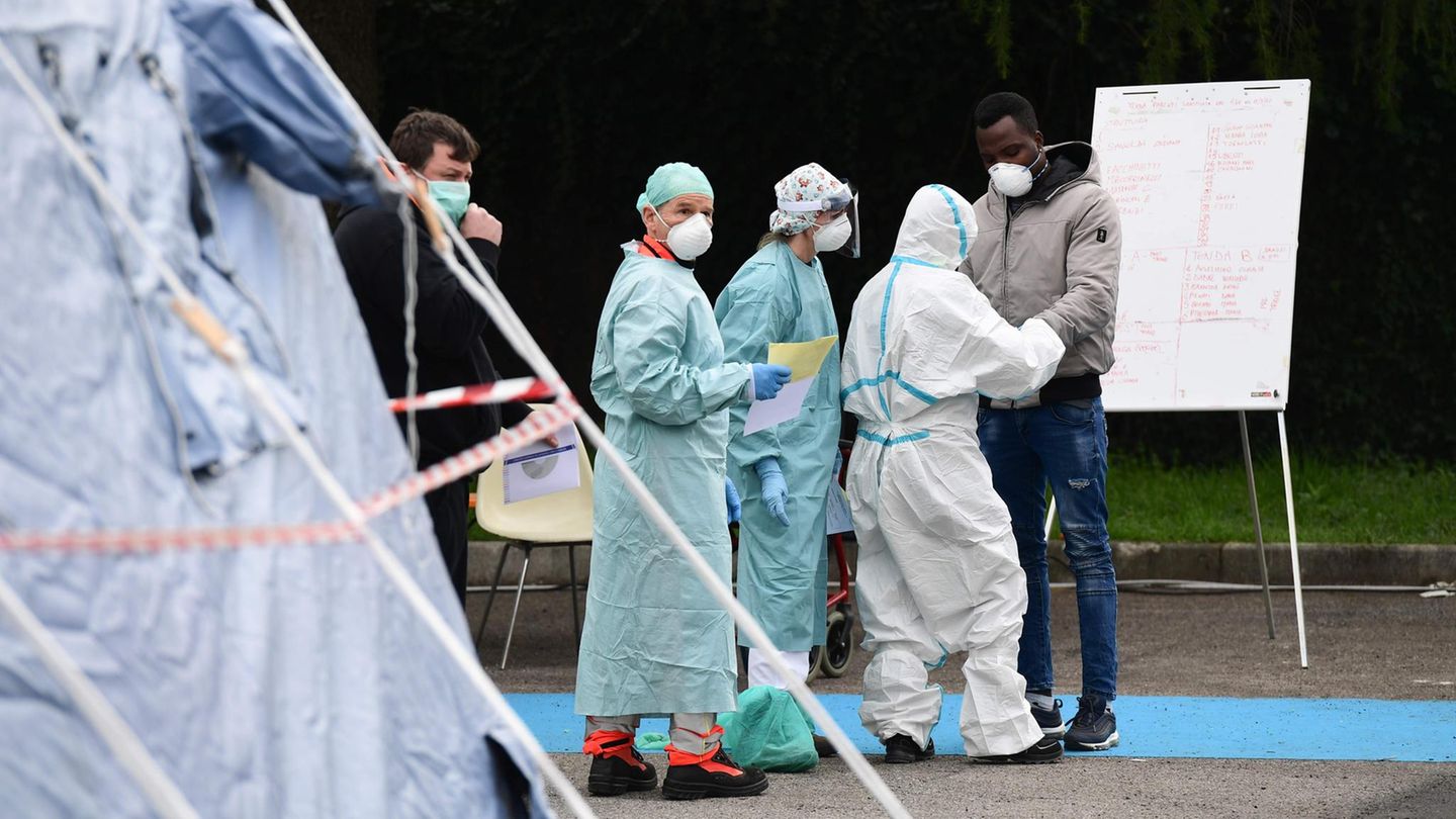Medizinisches Personal in Schutzanzügen testet einen Neuankömmling mit Corona-Verdacht vor dem Krankenhaus in Brescia