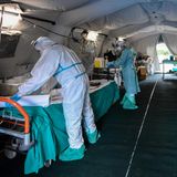 Medizinsches Personal in Schutzanzügen bereitet eine provisorische Triage-Stelle vor dem Krankenhaus in Brescia vor.