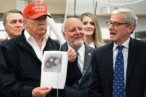 Donald Trump hält ein Bild des Virus in die Kamera