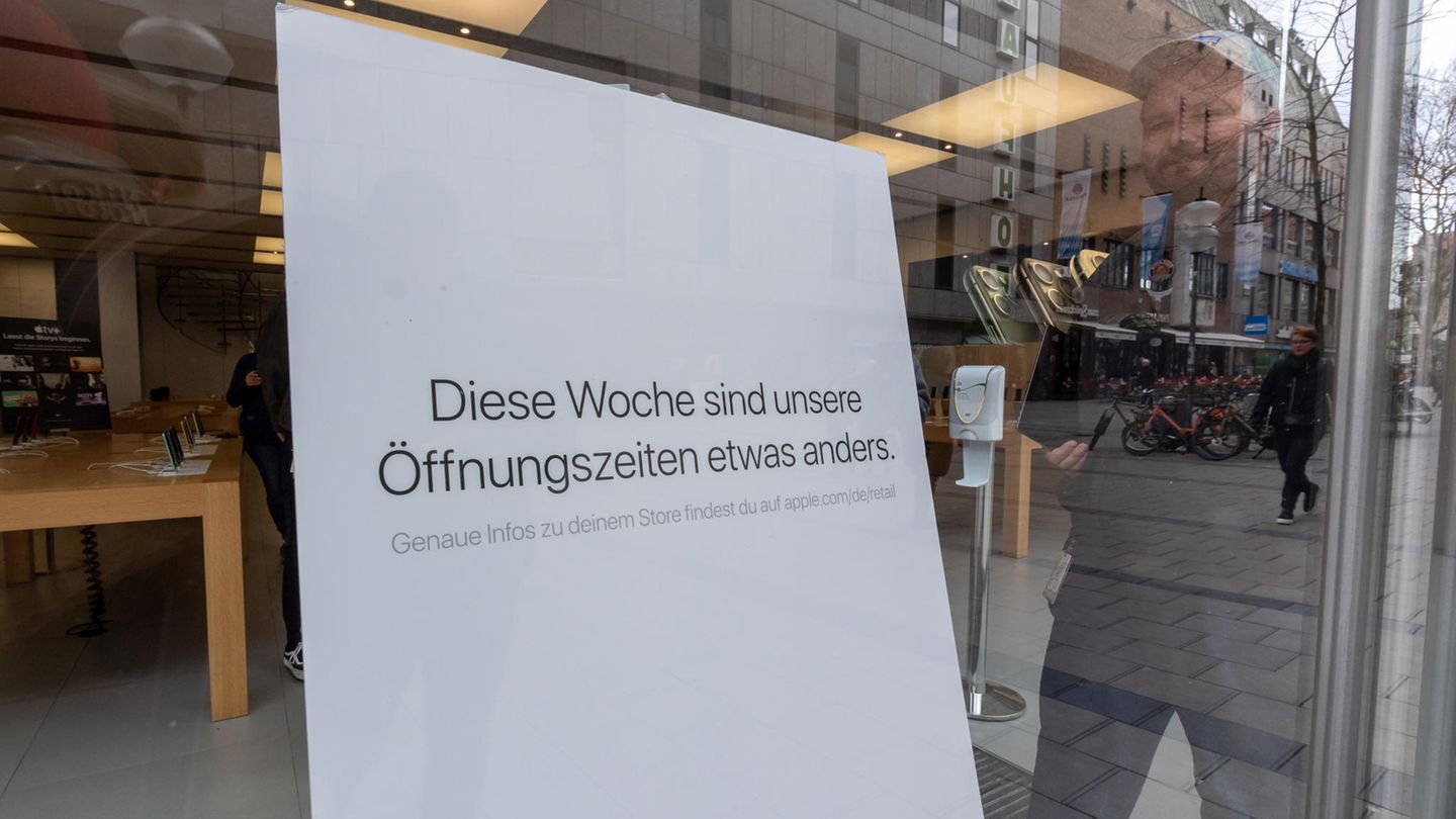 Schild mit der Aufschrift "Diese Woche sind unsere Öffnungszeiten etwas anders" vor einem Apple-Store in München