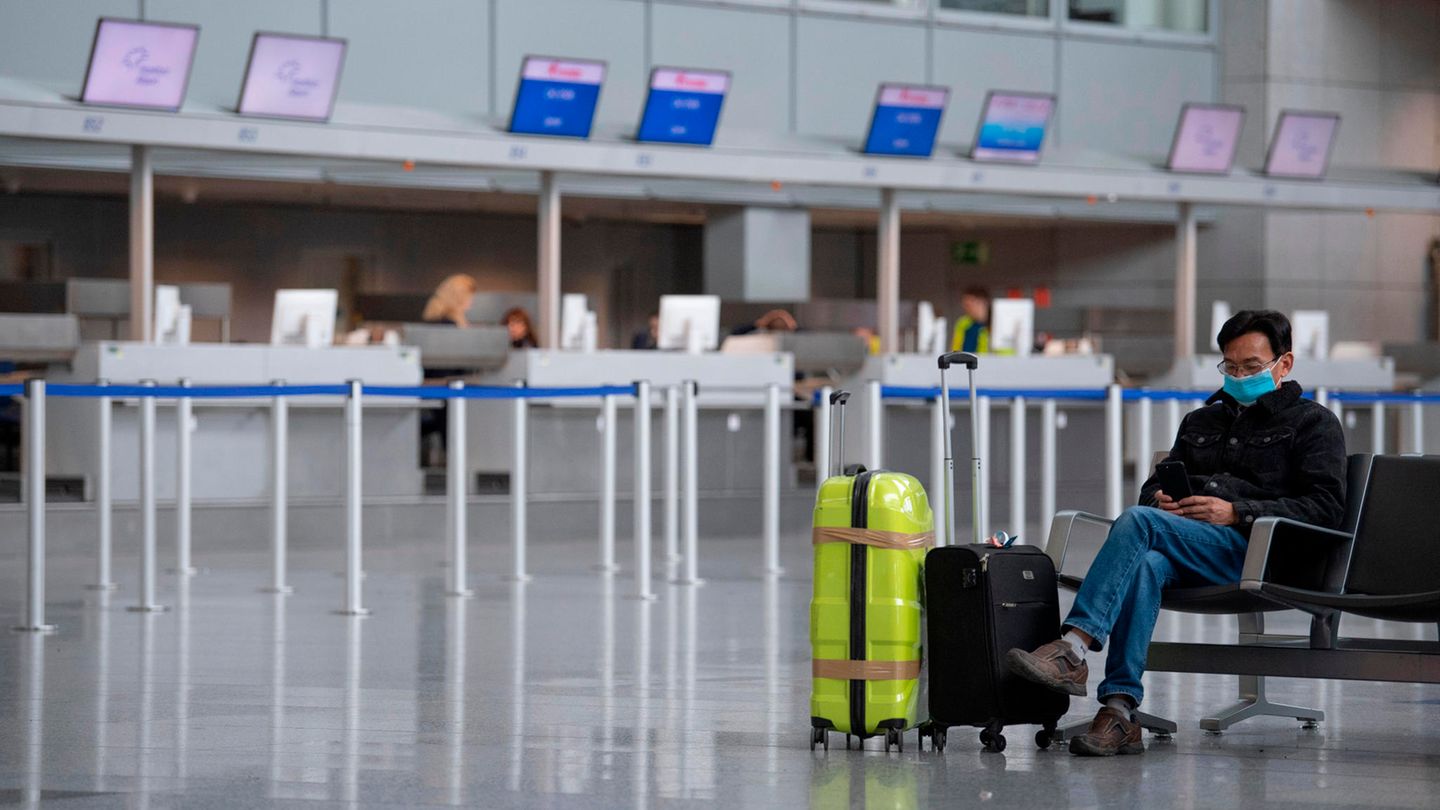 Mit einer Gesichtsmaske schützt sich dieser Mann in der Abflughalle des Terminals am Frankfurter Flughafen