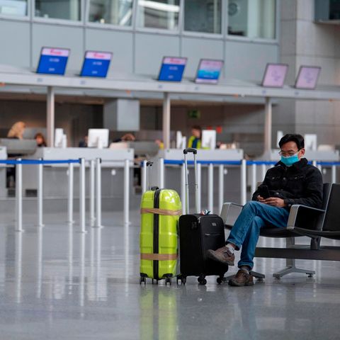 Mit einer Gesichtsmaske schützt sich dieser Mann in der Abflughalle des Terminals am Frankfurter Flughafen