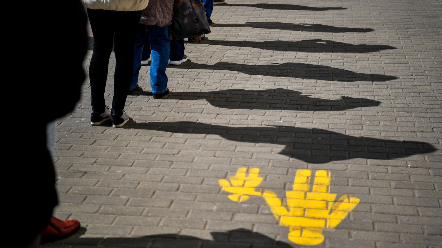 Social Distancing: Menschen in einer Schlange halten Abstand