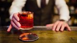 Ein Barkeeper hat einen Drink in der Hand