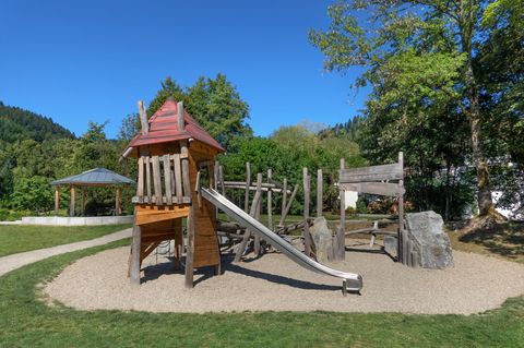 Spielplatz mit Holzhütte und Rutsche