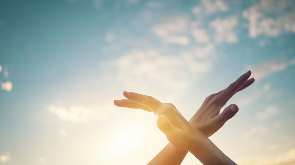 Frau hält Hände in den Himmel