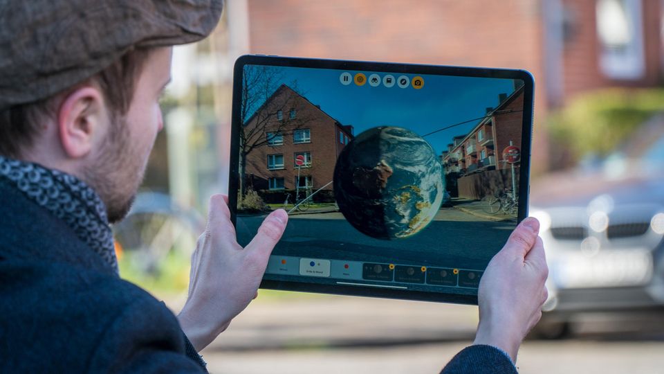 Ein Fingertipp, schon sieht man ein Modell der Erde mitten auf der Straße: Apple denkt, dass Augmented-Reality-Apps das Lernen revolutionieren könnten.