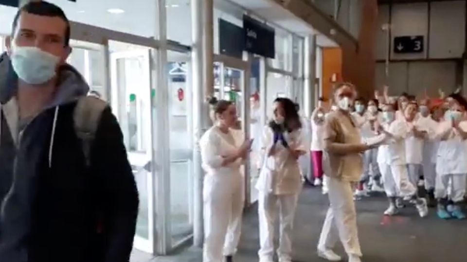 Das Krankenhauspersonal applaudiert dem entlassenen Patienten Das Krankenhauspersonal applaudiert dem entlassenen Patienten