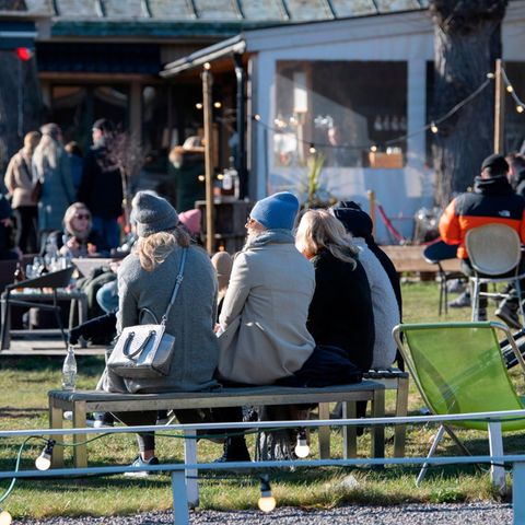 Menschen genießen das sonnige Wetter in einem Restaurant im Freien in Djurgarden in Stockholm