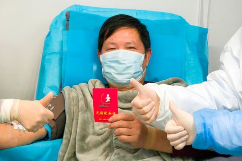 China, Wuhan: Ein genesener Coronavirus-Patient hält