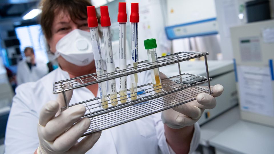 Laborant mit Reagenzgläsern in der Hand