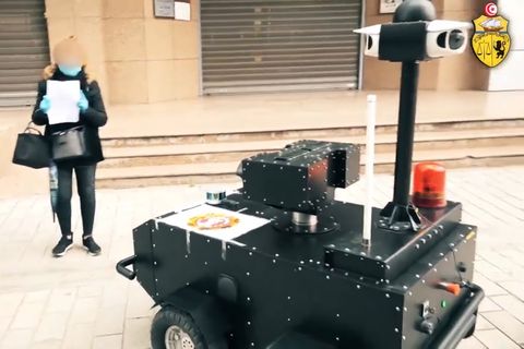 Coronavirus in Tunesien: Eine Frau zeigt einem Polizeiroboter ihre Bescheinigung bei Ausgangsbeschränkungen in Tunis