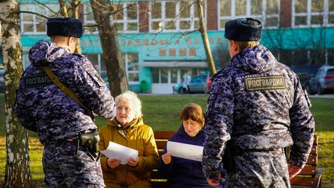 Moskau: Russische Soldaten der Nationalgarde sprechen mit zwei Rentnerinnen auf einer Parkbank.